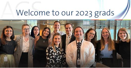 a group of 11 people under a banner saying Welcome to our 2023 grads