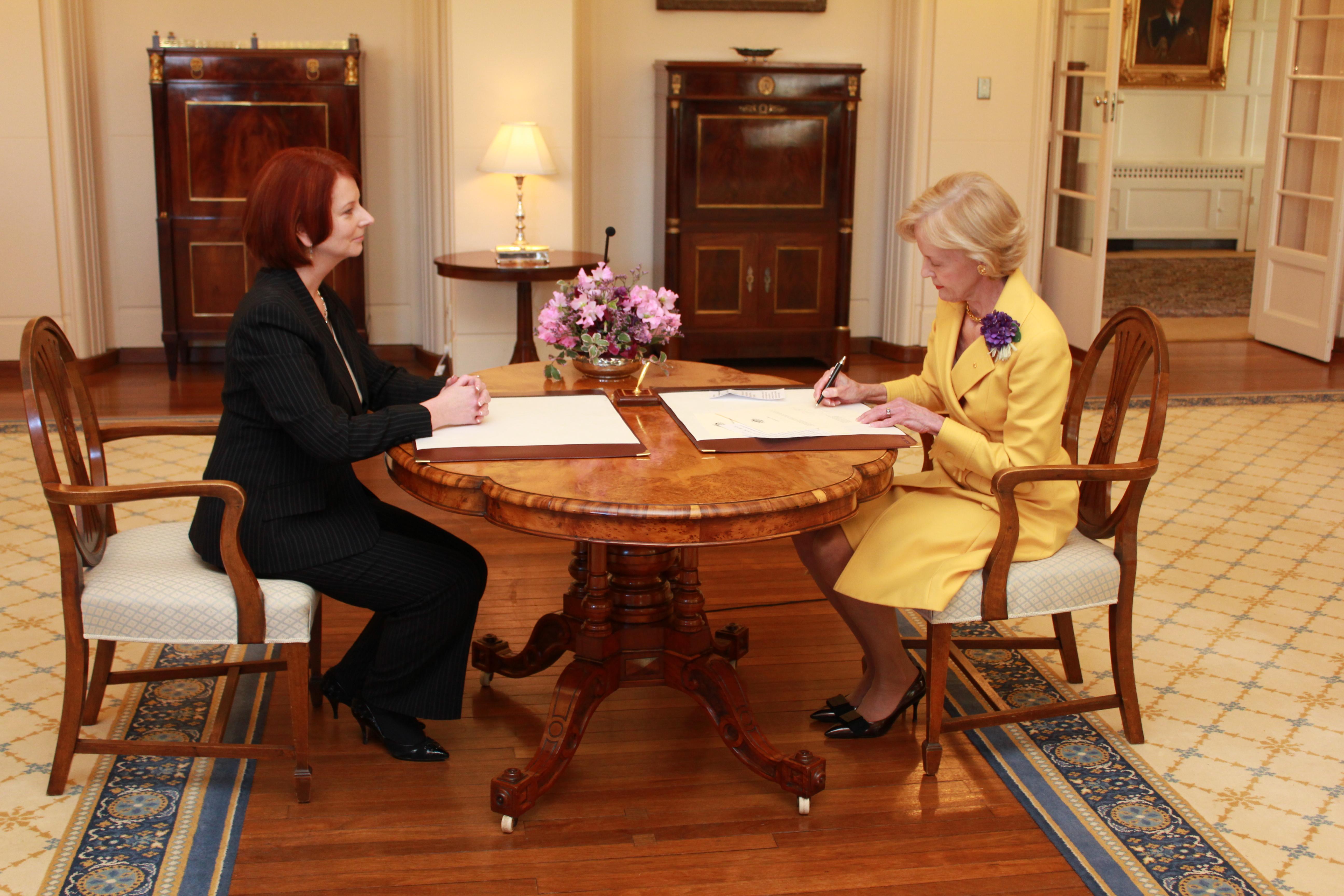 Julia Gillard (L) watches as Governor-General Quentin Bryce (R)&nbsp;signs her commission as Prime Minister, 25 May 2011.