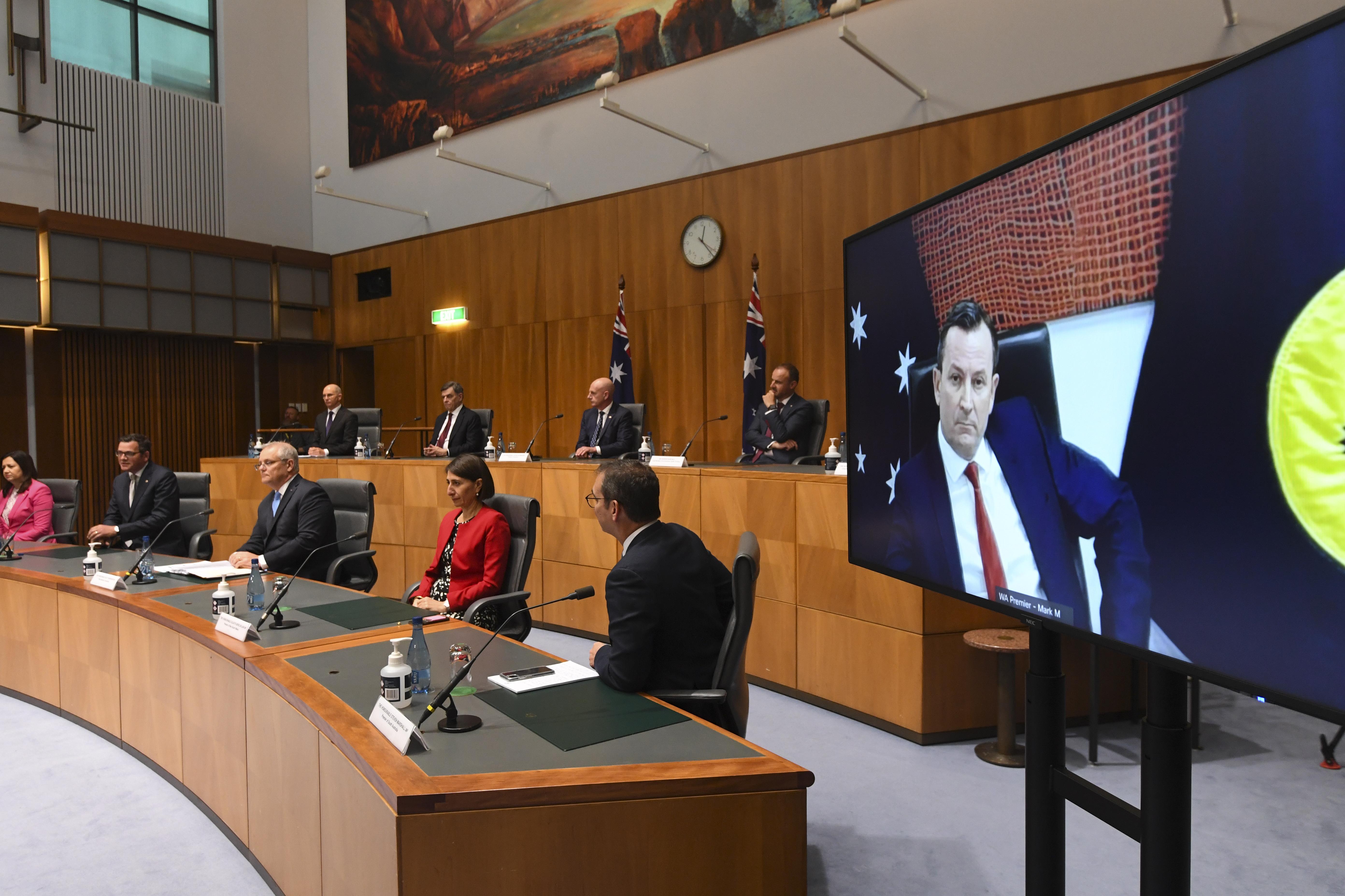 Australian Prime Minister Scott Morrison (C), together with State Premiers and Territory Chief Ministers, address the media during a press conference at Parliament House in Canberra, 11 December 2020.